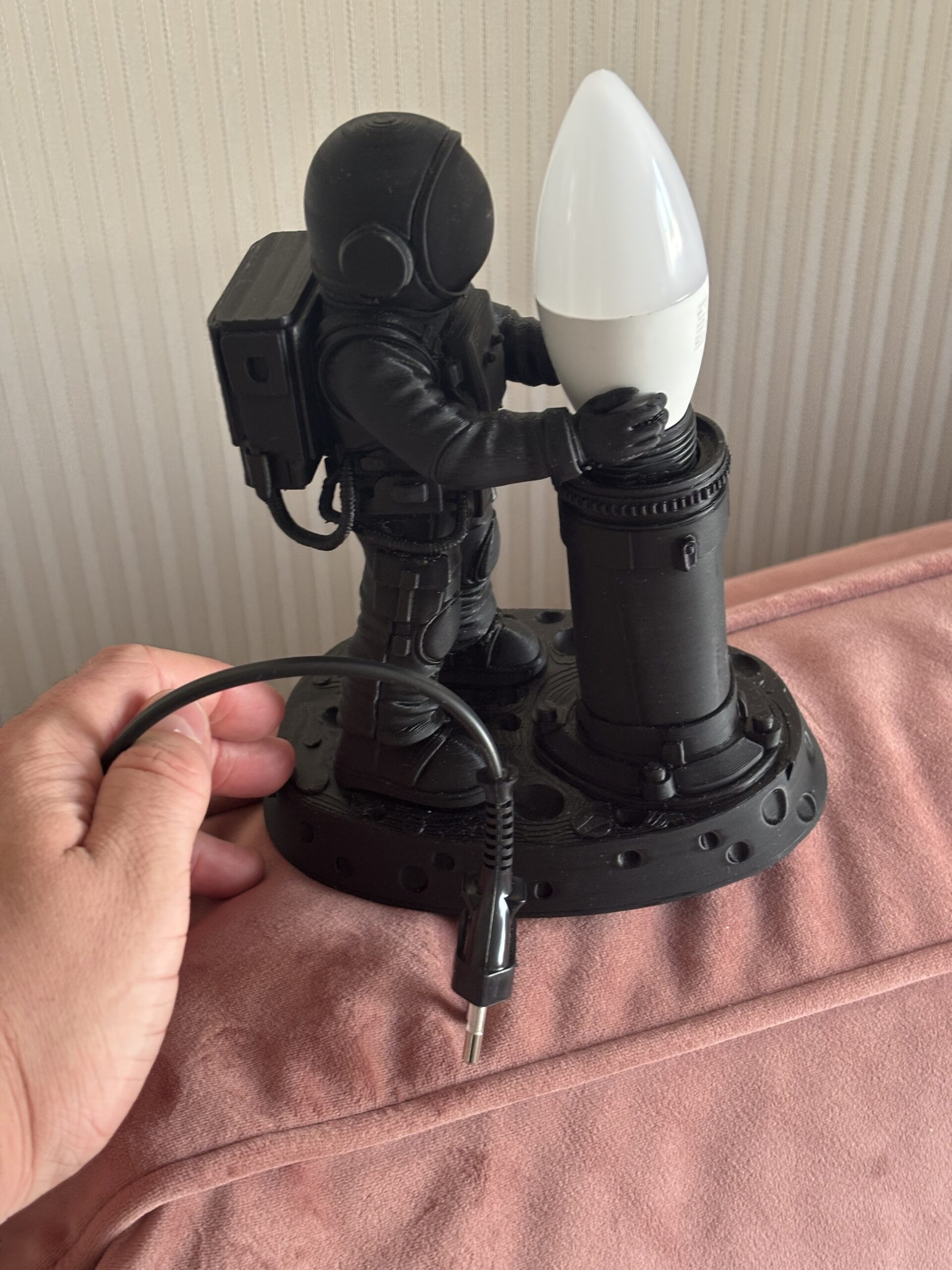 3D printed astronaut lamp holding a candle bulb on a moon base